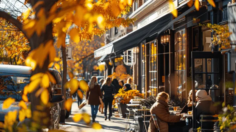 Sunny autumn day with bustling storefronts lined by vibrant fall foliage